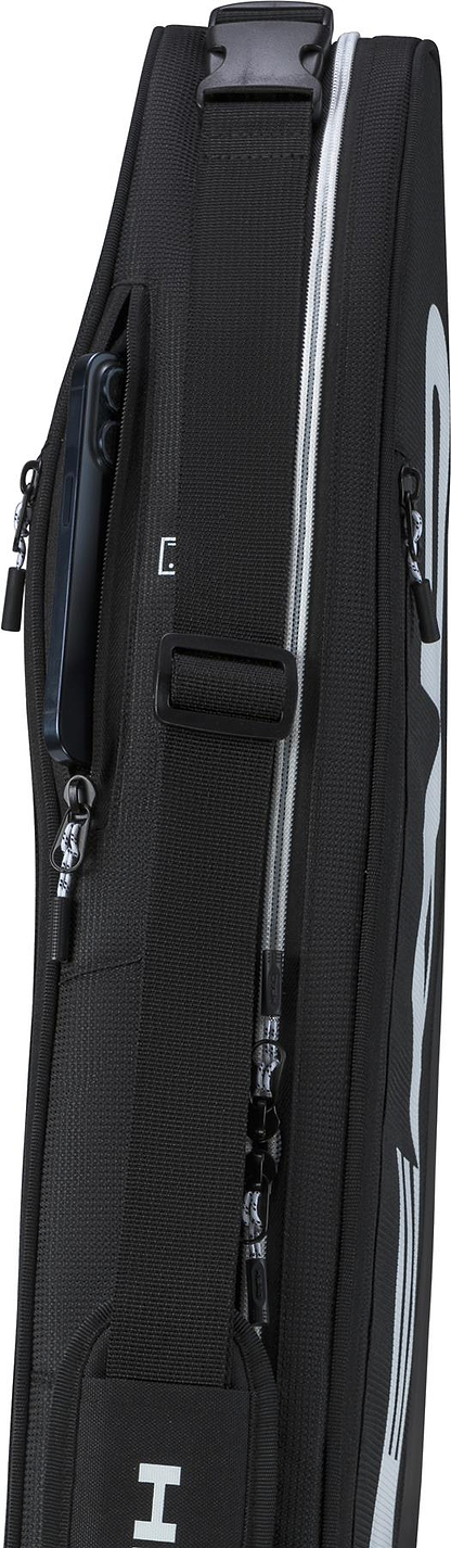 A close-up side view of the HEAD Tour 3 Racket Badminton Bag S - Black features zippers, a shoulder strap, and a smartphone partially tucked into a zippered pocket.
