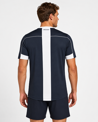 A man, seen from behind in a plain setting, wears the HEAD Play Tech Mens Badminton T-Shirt - Navy by HEAD with a white vertical stripe and moisture transfer microfiber, paired with navy shorts.