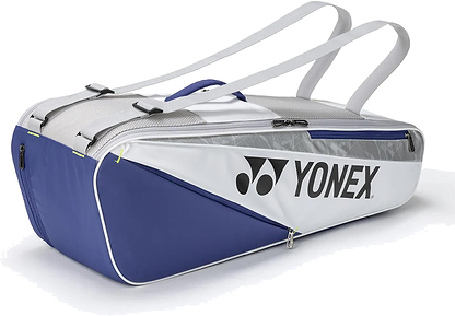 The Yonex BA52526EX Club 6 Racket Badminton Bag in white and blue features dual shoulder straps, zippered compartments for equipment, and the Yonex logo on the side.