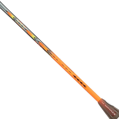 A close-up of the Victor Thruster Rocket O 4U Badminton Racket shaft in silver and orange shows bold black and yellow geometric designs with "WINNER" printed, highlighting the Victor brand against a white background.