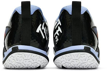 The image displays Li-Ning Saga II Lite Men's Badminton Shoes in black and white. They have a glossy black heel with white text, textured white sole, and upper accents in light blue and black, complete with a back pull tab, blending performance with style effortlessly.
