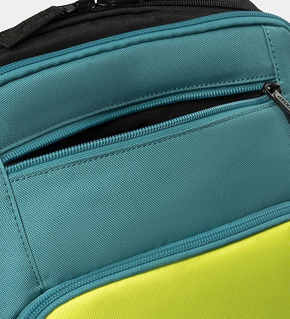 The Dunlop SX Performance Badminton Backpack features a teal and black design with a zippered pocket and bright yellow lower section. The top has black trim, possibly part of a strap or handle, making it perfect for serious players.