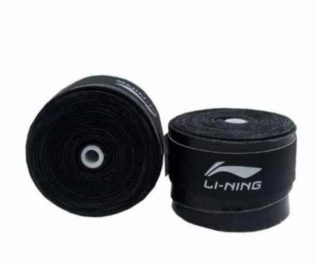 Two black Li-Ning Badminton Overgrips are displayed, with one positioned upright and the other lying flat. Both feature the Li-Ning logo and name in white print. These absorbent grips are rolled, super tacky, and ready for use.
