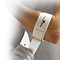 A person securing a white Precision Tennis Elbow Strap around their wrist. Crafted as a lightweight compression accessory, the strap features the "Precision" logo with a subtle red and black design, making it ideal for preventing overuse injuries. The image is partially faded on the left side.