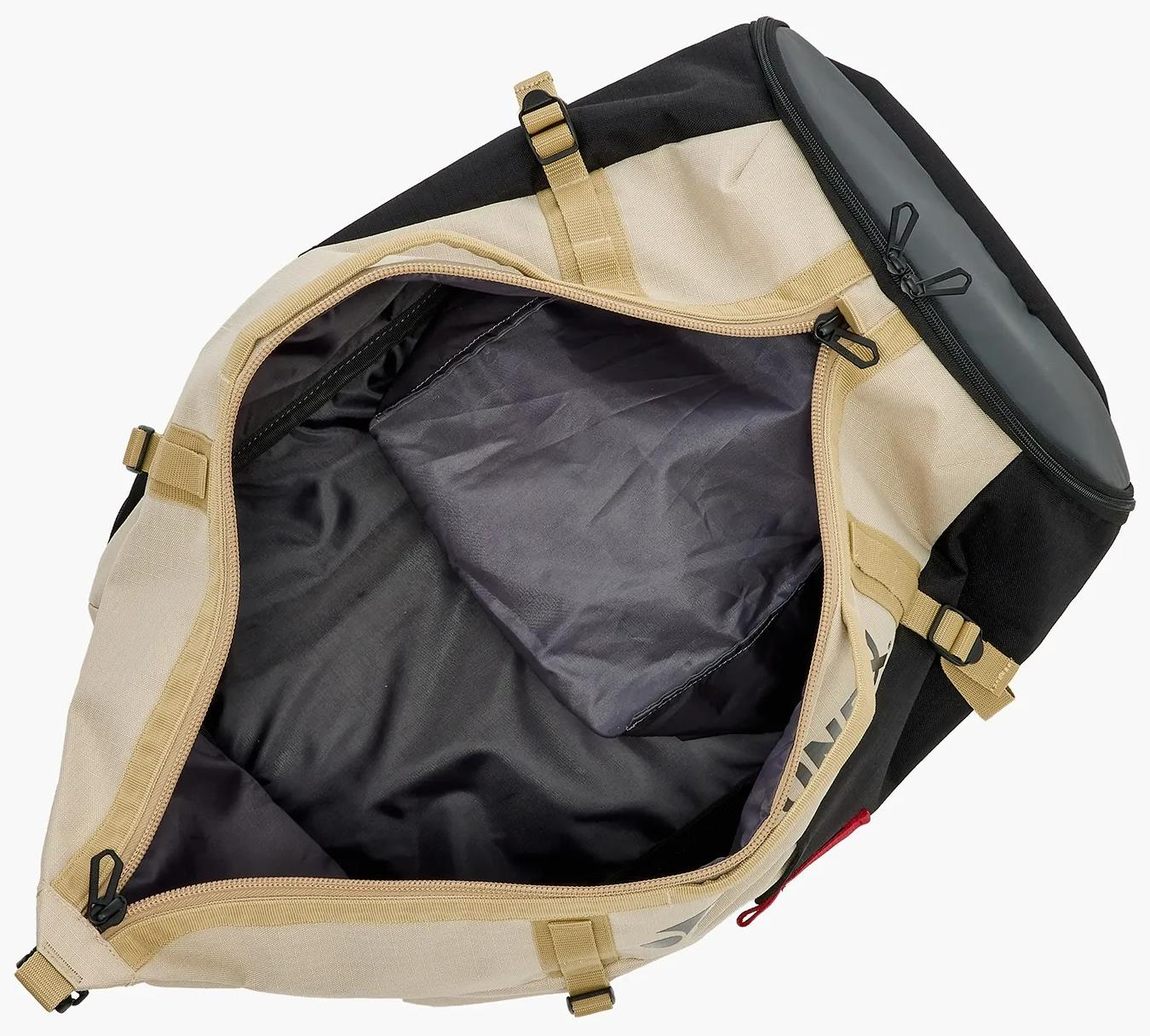 The Yonex BA72612EX Gearlogic Badminton Backpack in beige is shown open from above, revealing a spacious dark-lined interior and side pocket—featuring sturdy zippers and buckles, ideal for your badminton essentials.