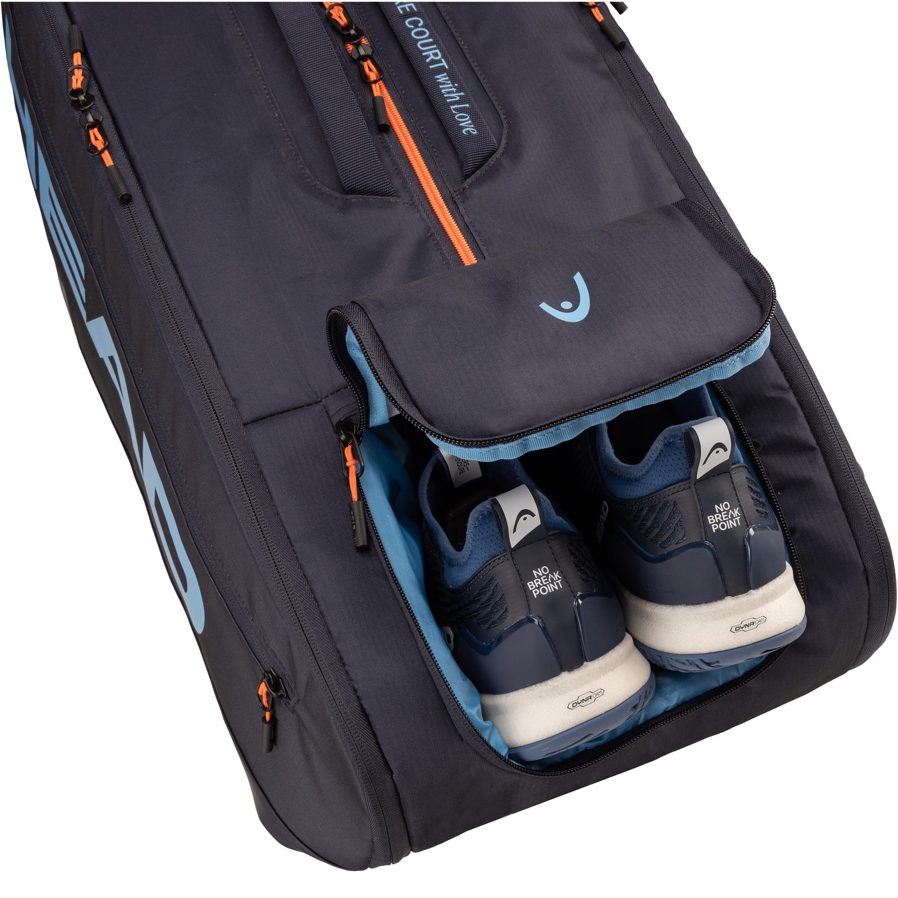 A close-up of the HEAD Pro 12 Racket Badminton Bag XL - Navy shows its open compartment with navy athletic shoes featuring white soles and “NO FOR” on the heel tabs, plus light blue accents for a tournament-ready look.