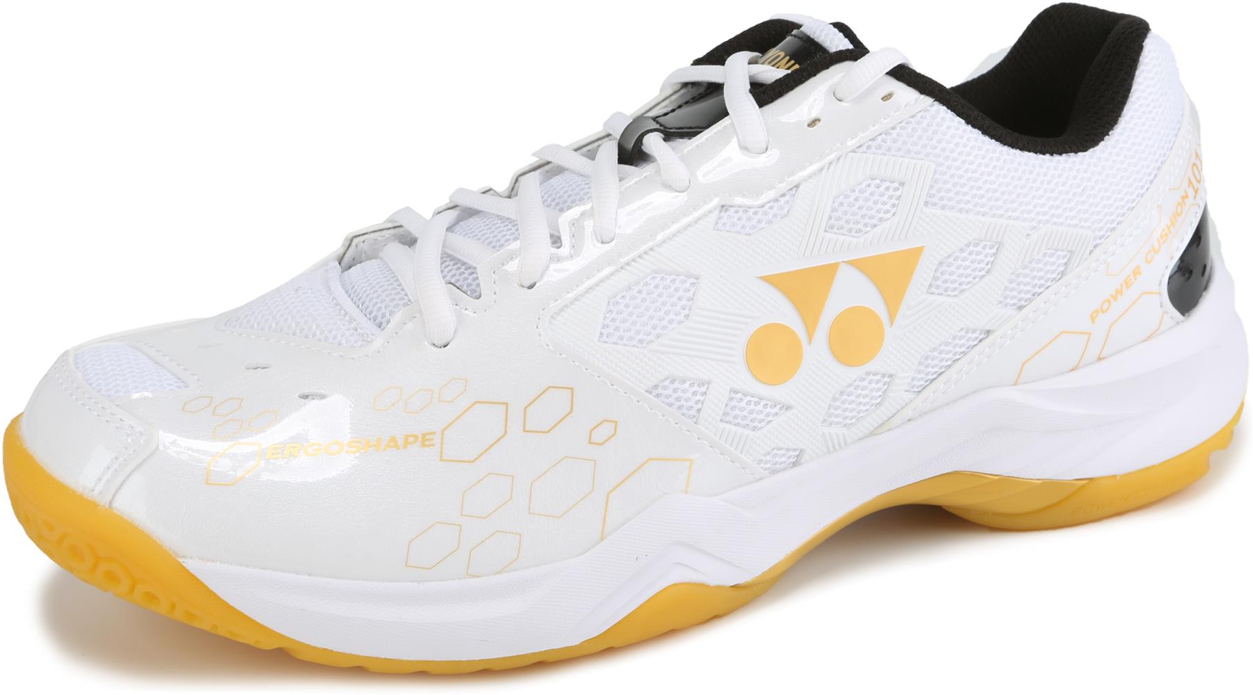 The Yonex Power Cushion SHB 101 Badminton Shoes in White/Gold have a honeycomb pattern, mesh panel, yellow logo, yellow and white shock-absorbing sole, plus black lining and laces.
