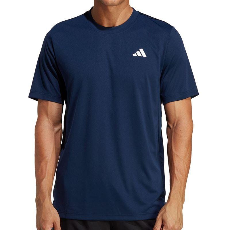 A person wearing the ADIDAS Men's Club Badminton T-Shirt in navy from adidas, featuring a small white logo on the chest. This shirt, made with AEROREADY fabric, has short sleeves and the person is standing against a plain background.