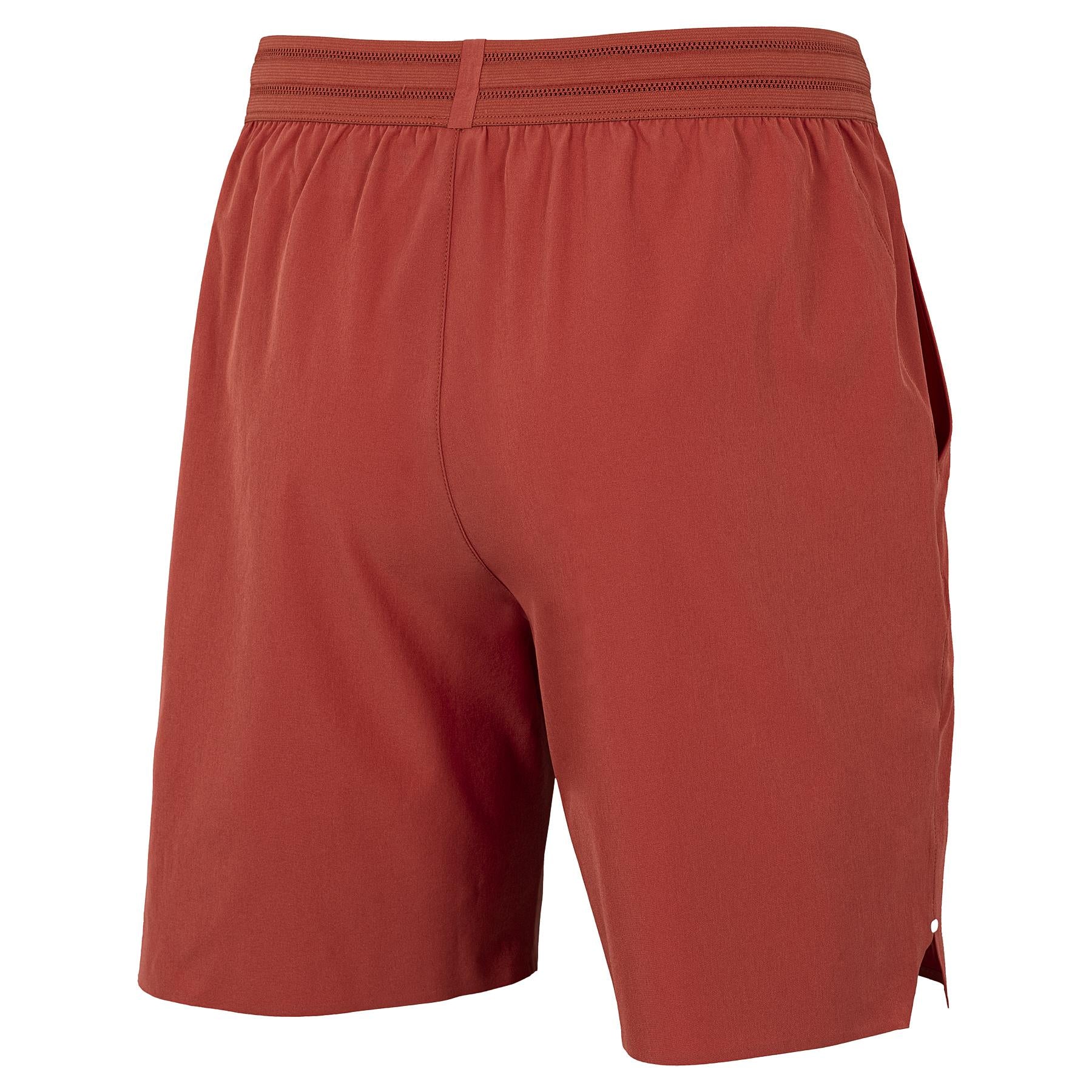 The Tecnifibre Team Stretch Men's Badminton Shorts in terracotta are shown from the back, featuring an elastic waistband and a plain, logo-free design.