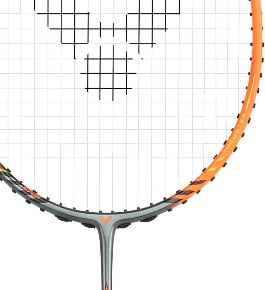 A close-up of the Victor Thruster Rocket O 4U Badminton Racket in silver and orange shows its head-heavy Power Box frame, grid string pattern, and bold "THRUSTER" lettering along the right side.