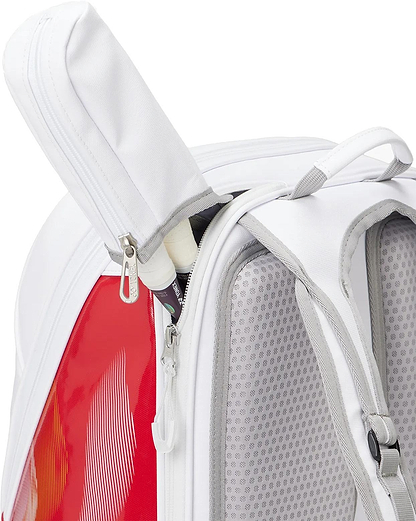 A close-up of the Yonex 02612EX Expert Badminton Backpack - White shows a zippered pocket partially open to reveal two white-handled racquets inside. The Yonex backpack features padded straps and mesh details.