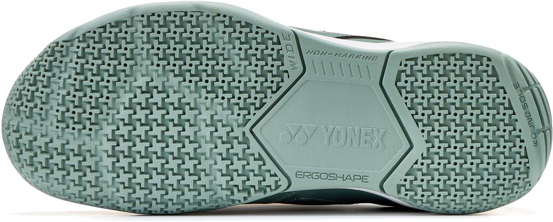Close-up of the sole of Yonex Strider Ray WIDE Unisex Badminton Shoes - Khaki, showing a textured, non-marking rubber pattern with "YONEX" and "ERGOSHAPE" logos, highlighting superior grip and comfort from Power Cushion technology.