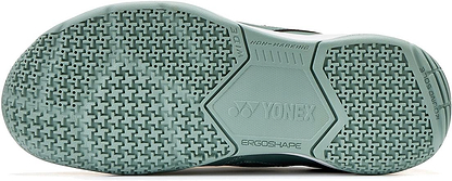 Close-up of the sole of Yonex Strider Ray WIDE Unisex Badminton Shoes - Khaki, showing a textured, non-marking rubber pattern with "YONEX" and "ERGOSHAPE" logos, highlighting superior grip and comfort from Power Cushion technology.