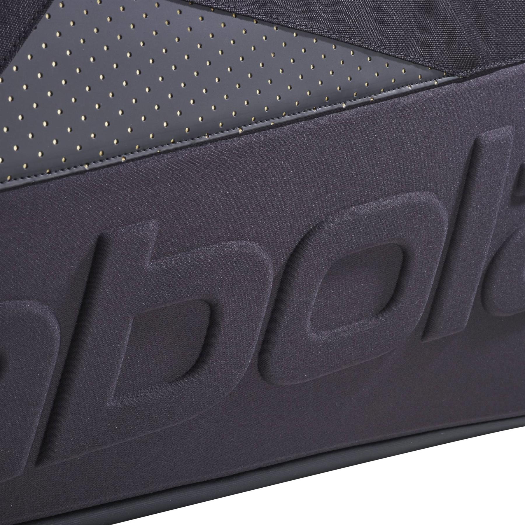 Close-up of a Babolat Cross Pro Badminton Bag - Black / Gold showing the embossed "Babolat" logo and small perforated holes above its thermoformed shell.