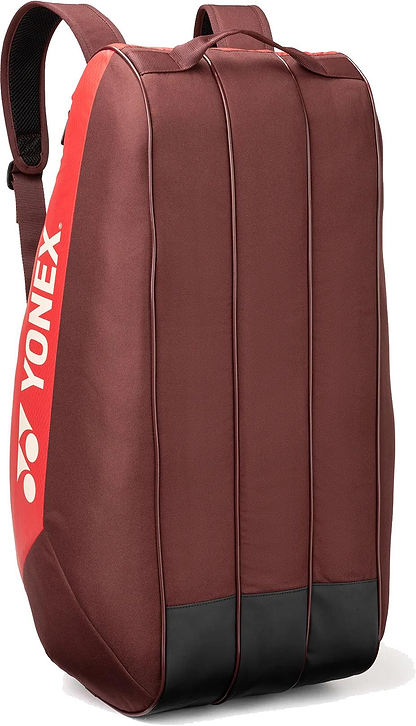 The Yonex 42529EX Team 9 Racket Badminton Bag in ruby red features black accents, vertical front lines, padded shoulder straps, and a white Yonex logo—ideal for players seeking a stylish and functional Yonex bag.