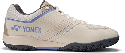 The Yonex Strider Flow WIDE Men's Badminton Shoes in light beige feature blue and grey accents, the Yonex logo on the side, a textured black sole, and white laces—ideal for beginners.