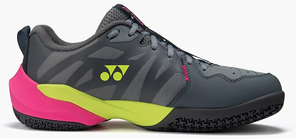 The Yonex Subaxia GT WIDE Unisex Badminton Shoes in grey feature a black sole, neon yellow midsole accent, bright pink heel, gray laces, geometric logo, pink lace-area text, and advanced GRPHT THRTTL tech for superior grip.