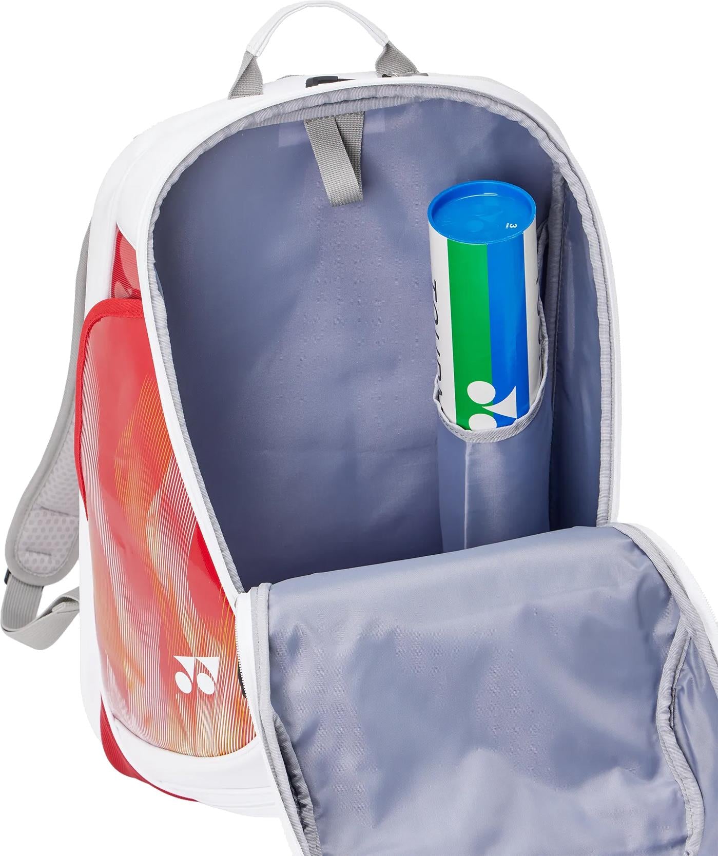 The Yonex 02612EX Expert Badminton Backpack - White, by Yonex, is unzipped and open to reveal a gray interior with a can of tennis balls in the inner pocket. Its red and white exterior proudly displays the Yonex logo.