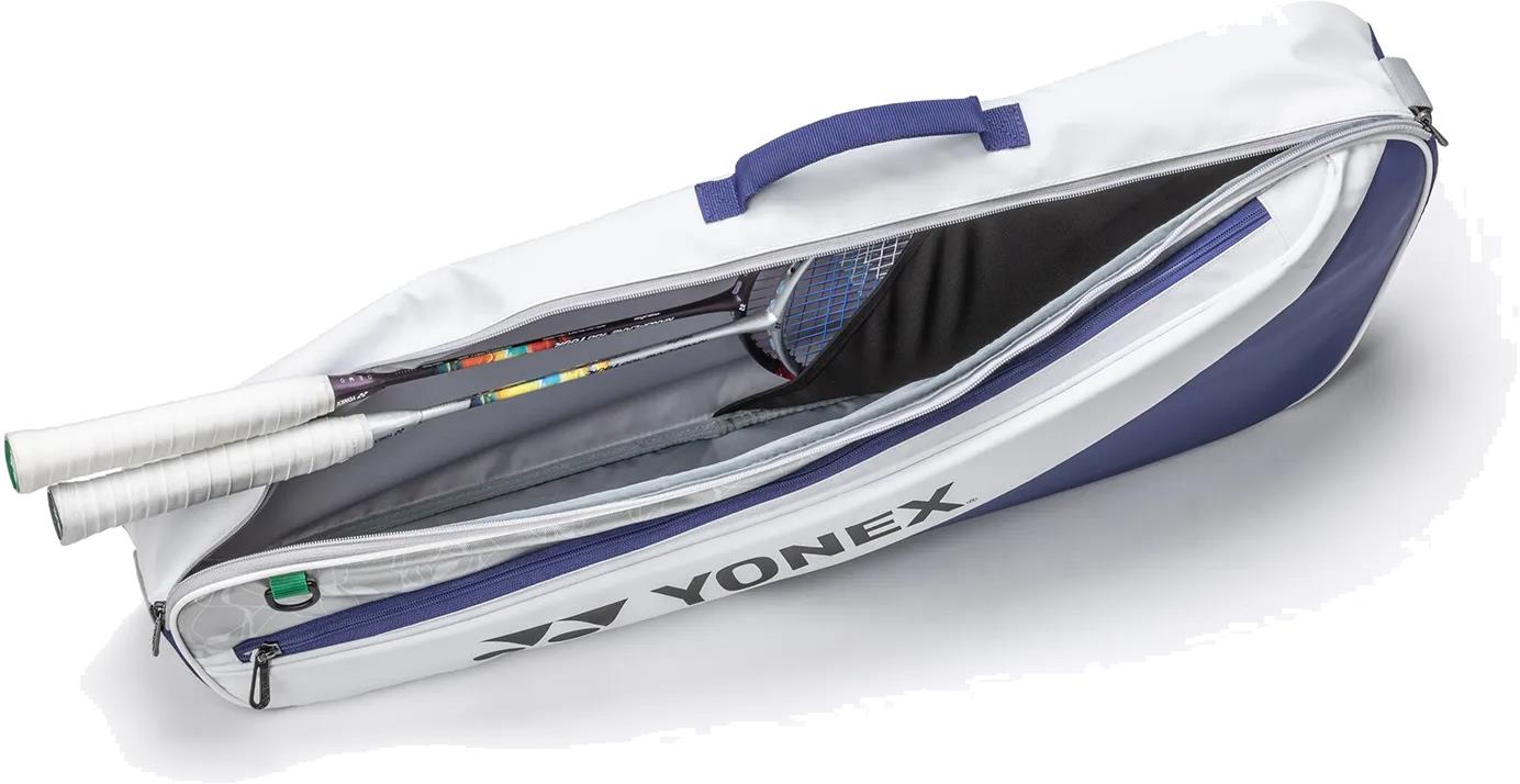 The Yonex BA52523EX Club 3 Racket Badminton Bag in white and blue is shown unzipped, revealing two racquets with white grip handles inside. This lightweight Yonex bag features a side logo and a convenient carrying handle.