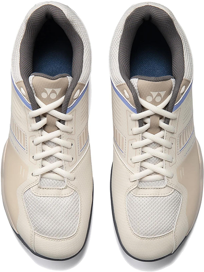 A pair of Yonex Strider Flow WIDE Men's Badminton Shoes in light beige, featuring mesh fabric, textured panels, laces, and a logo on the tongue—ideal for beginner players. Viewed from above.