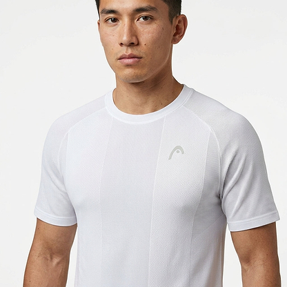 A man with short dark hair wears the HEAD Performance Men's Badminton T-Shirt in white, featuring a subtle chest logo. This HEAD sportswear offers moisture-wicking fabric for all-day comfort, shown against a plain white background.