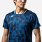 A man models the Yonex 10712YX Crew Neck Men's Badminton T-Shirt in indigo blue with a geometric pattern and small white Yonex logo on the left chest, standing against a plain white background.