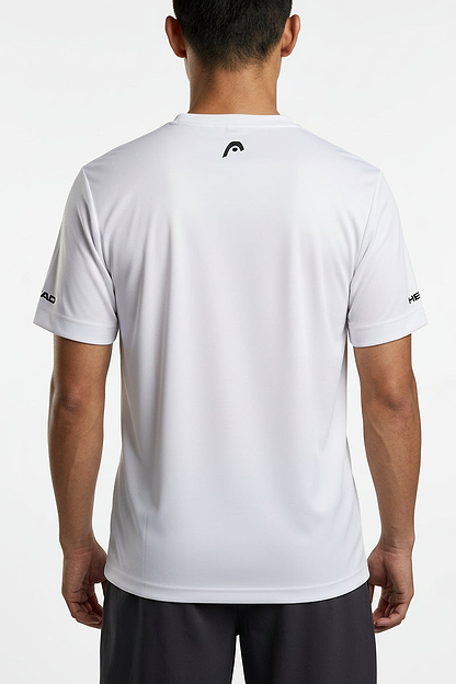 A man faces away from the camera, wearing a white HEAD Blur Men's Badminton T-Shirt - PUXU, featuring black logo accents on the sleeves and upper back, paired with dark shorts against a plain light background.