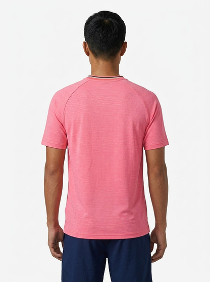 A man with short black hair faces away from the camera, wearing the K-Swiss Hypercourt Mens Melange 3 Badminton T-Shirt in pink and dark blue shorts, set against a plain white background.