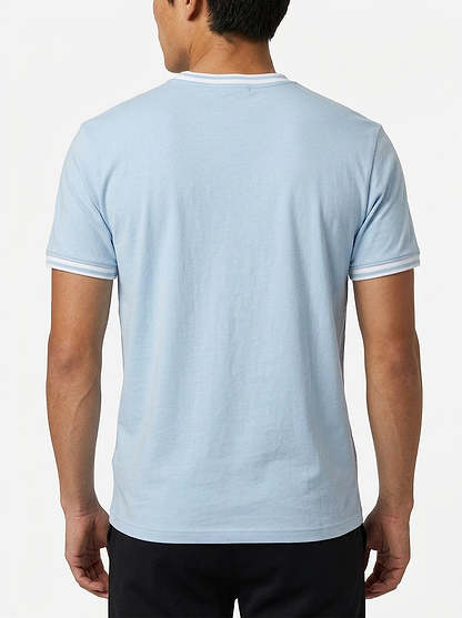 A person stands with their back to the camera, wearing the Tecnifibre Team Stretch Men's Badminton T-Shirt in Glacier Blue with white trim and black pants, against a plain white background.