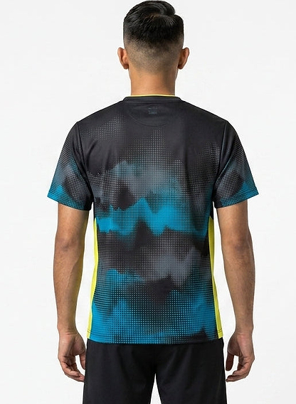 A man with short dark hair is seen from behind, wearing a Yonex YTM2025A Mens Badminton T-Shirt in black with a pixelated pattern and yellow side panels, plus black shorts, standing against a plain white background.