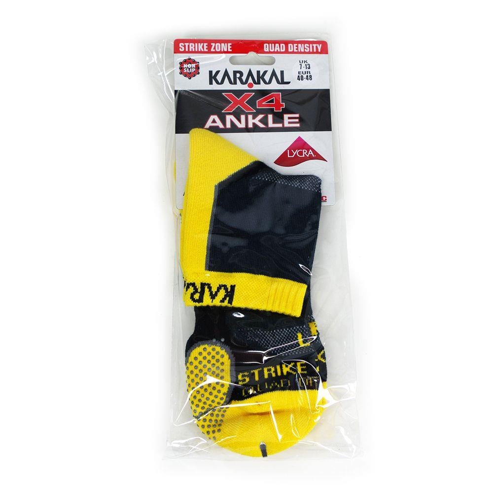 A package of Karakal X4 Men's Technical Ankle Badminton Socks in black and yellow, made with Cool Tec material for maximum comfort. The packaging features "Strike Zone," "Quad Density," and "Lycra" labels. Crafted to be shock absorbing, they are suitable for UK sizes 7-13. The socks are visible through the transparent plastic packaging.