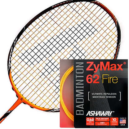 An Ashaway Zymax 62 Fire badminton racket with orange strings rests next to a packet of Ashaway ZyMax 62 Fire string, renowned for its high-performance playability. This packet highlights its maximum repulsion and tension maintenance capabilities and features a sleek black and red design with vibrant orange accents.