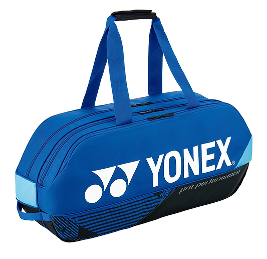 A Yonex 92431WEX Pro Tournament 6 Racket Badminton Bag in cobalt blue, featuring black straps and YKK zippers, prominently displays the white Yonex logo. This badminton bag is expertly crafted to carry sports gear, with "pro performance" elegantly printed on the side.
