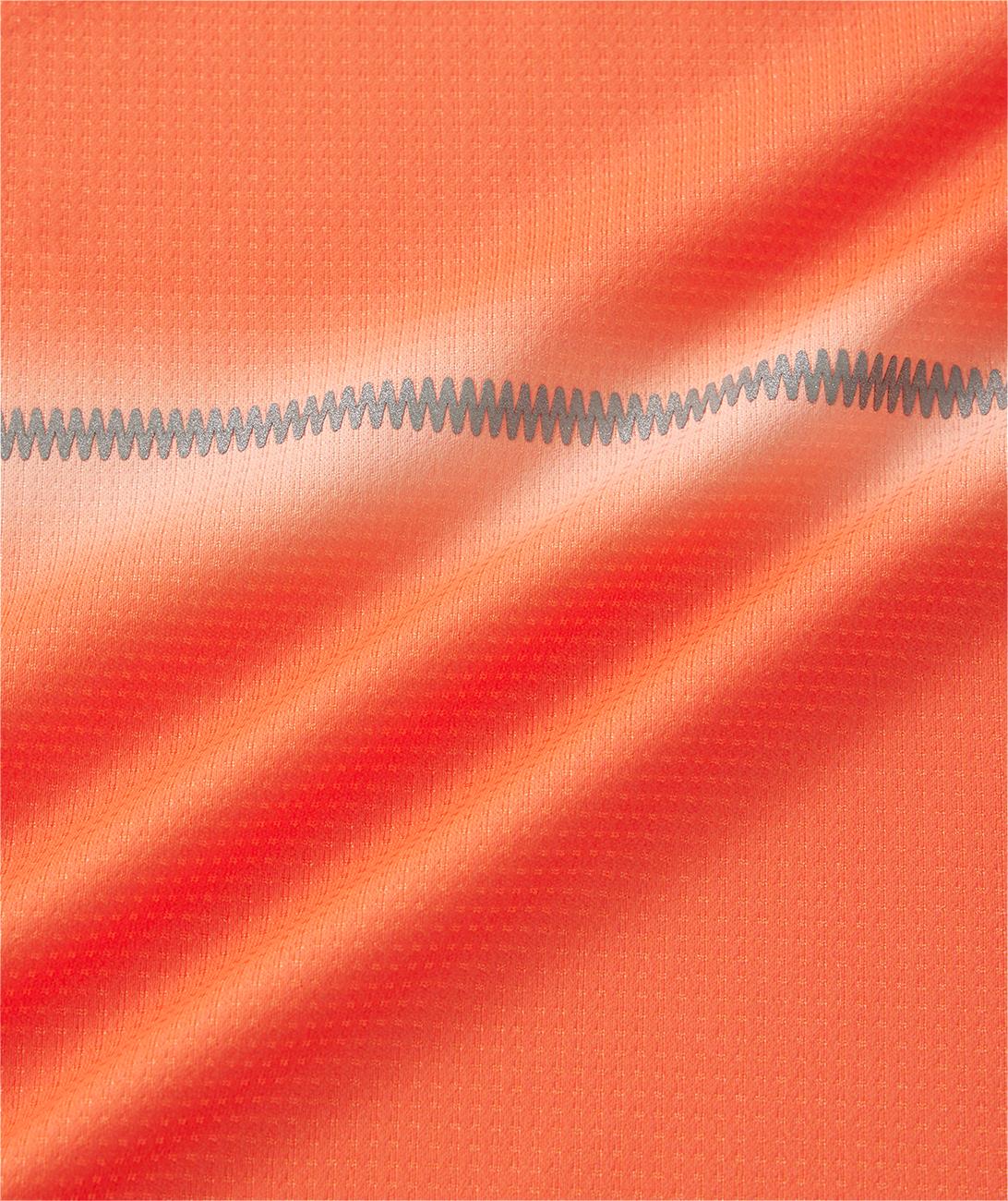 Close-up of Yonex 10711YX Crew Neck Men’s Badminton T-Shirt in Cyber Orange, featuring performance sportswear fabric with a subtle grid texture, gray zigzag stitching across the center, gentle folds, and light reflections.