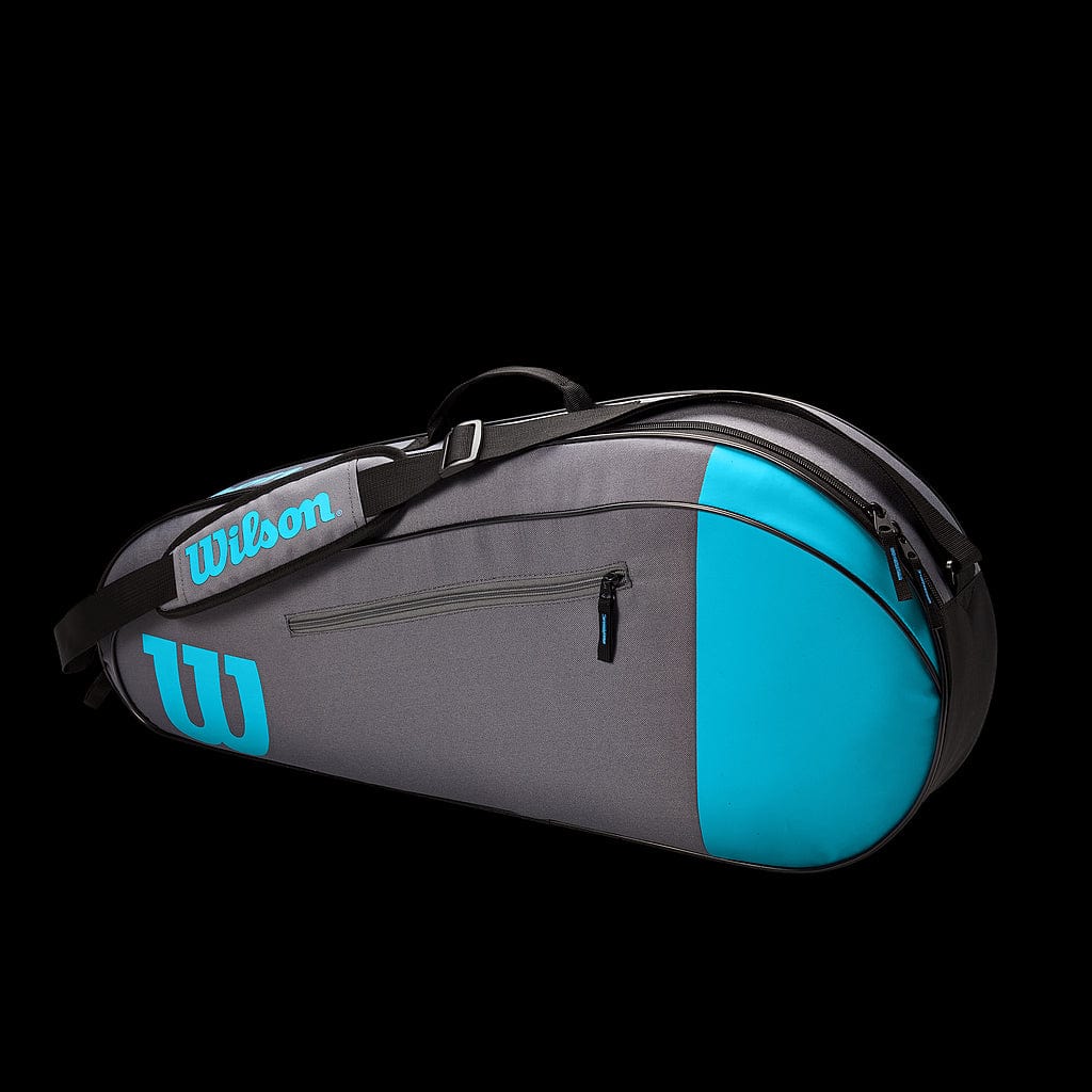 The Wilson Team Collection 3 Racket Bag, available in blue and grey, is a stylish and functional accessory for carrying your tennis equipment. It includes a zipper pocket, an adjustable shoulder strap, and the iconic Wilson logo in teal.