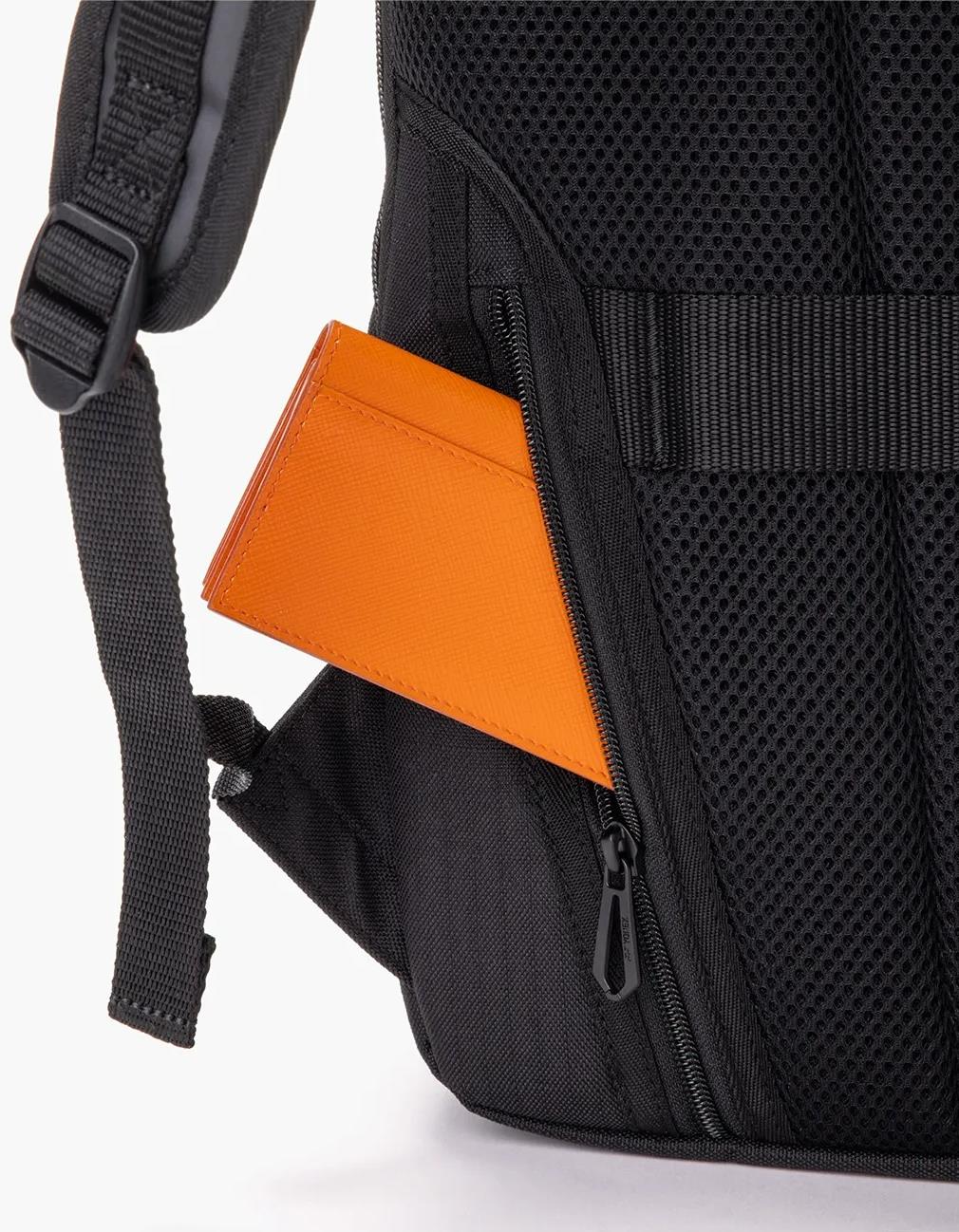 An orange wallet is partially tucked into a zippered side pocket of the Yonex BA72612EX Gearlogic Badminton Backpack in beige, featuring padded mesh fabric and adjustable straps.