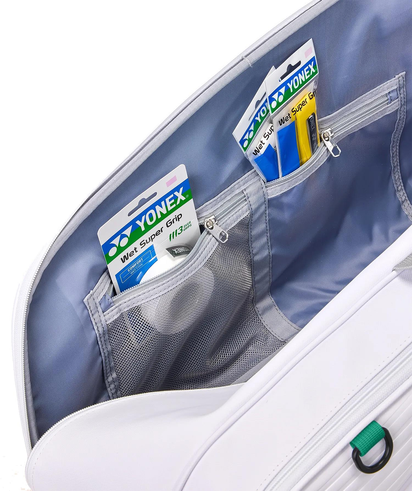 Close-up of the Yonex 02626EX Expert 6 Racket Badminton Bag - White's interior, showing two compartments neatly organizing Yonex Wet Super Grip packages with mesh and zippered sections for streamlined storage.