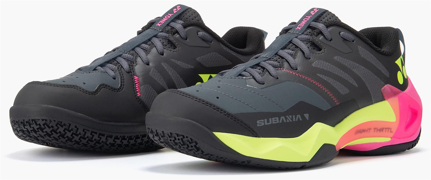 Yonex Subaxia GT Men's Badminton Shoes in dark grey feature neon yellow, pink, and green accents, GRPHT THRTTL technology, the "SUBAXIA" branding on the side, and a textured sole designed for top performance.
