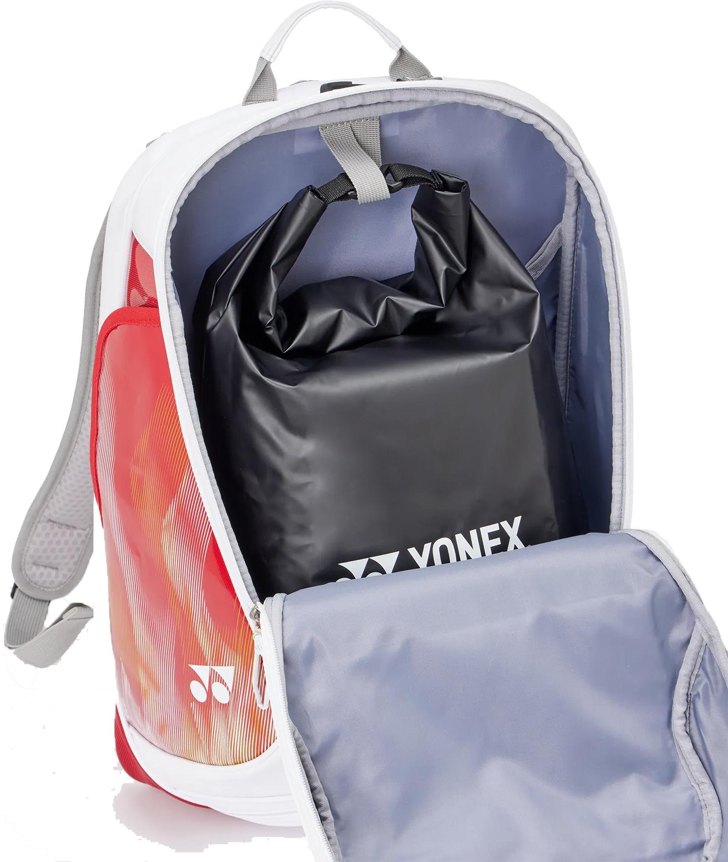 The Yonex 02612EX Expert Badminton Backpack - White is shown with its front compartment open, revealing a black Yonex roll-top pouch inside. The stylish bag, by Yonex, features white, red, and orange accents and adjustable shoulder straps.