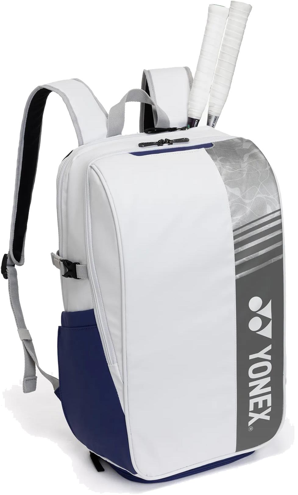 The Yonex BA52512EX Club Badminton Backpack in white and blue features a gray Yonex logo on the front, padded shoulder straps, and a top racquet compartment holding two tennis racquets.