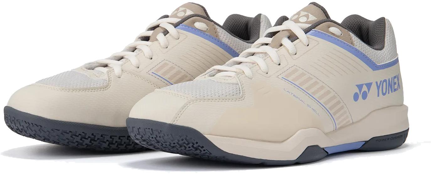 The Yonex Strider Flow WIDE Men's Badminton Shoes in light beige offer comfort and style with laces, textured soles, and the Yonex logo—ideal for beginners.