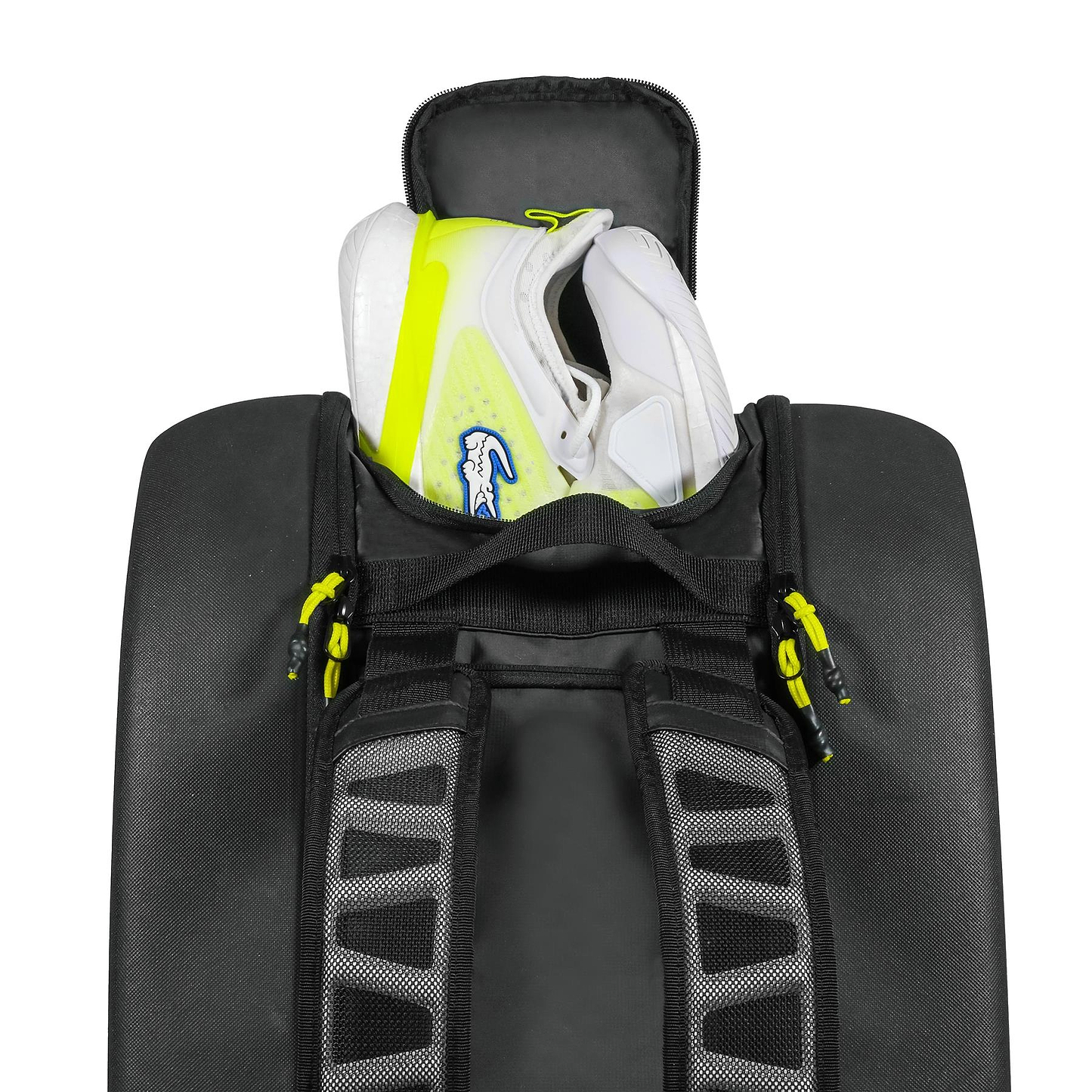 A pair of white sneakers with yellow accents and lightweight EVA soles are partially packed inside a Tecnifibre Reform L Badminton Racket Bag - Black, featuring gray straps and yellow zipper pulls by Tecnifibre.