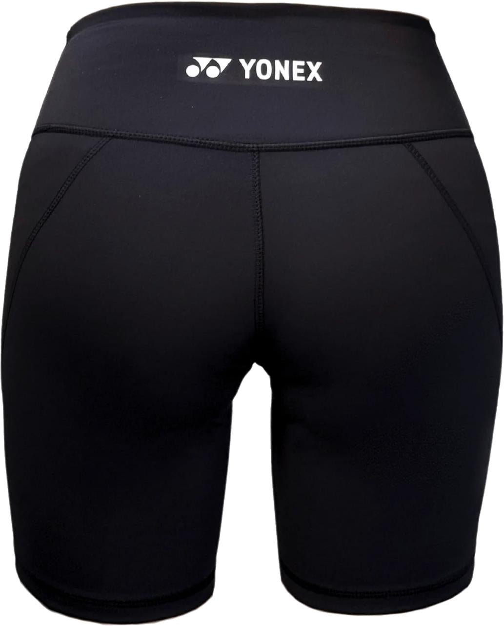 The Yonex YTS2024 Womens Core Badminton Shorts in black are shown from the back, highlighting the Yonex logo and brand name on the waistband and visible stitching that outlines the shape and seams.