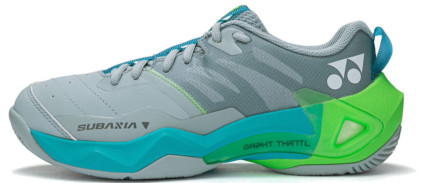 The Yonex Subaxia GT 2026 Women's Badminton Shoes in Grayish Green feature teal, blue, and green accents with blue laces, side and heel logos, and a thick sole equipped with advanced Power Cushion Rev technology for superior comfort.