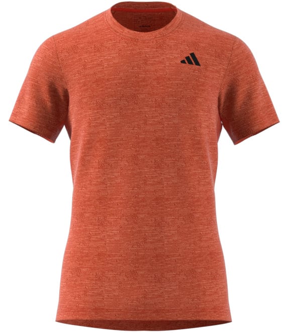 This adidas Men's Freelift AEROREADY T-shirt for badminton sports a solid red design with short sleeves, highlighted by a discreet black logo on the upper left side. The fabric includes a subtle textured pattern, providing both style and breathability for every match.
