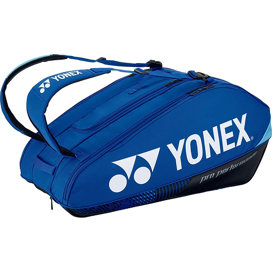 The Yonex 92429EX 9 Racket Pro Badminton Bag in cobalt blue, featuring black accents and the iconic logo, prominently displays "Pro Performance" text. It is equipped with YKK zippers and a Thermo Guard lining, providing multiple compartments and dual shoulder straps for convenient carrying.