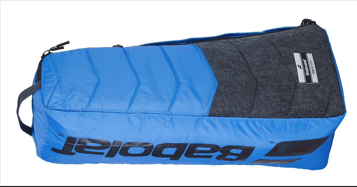 The Babolat RH6 Evo Drive Badminton 6 Racket Bag in blue and grey is a spacious duffel bag that prominently displays the Babolat brand name in black lettering. Designed to hold up to 6 badminton rackets, it features multiple compartments and a zipper closure to meet all your sporting needs.