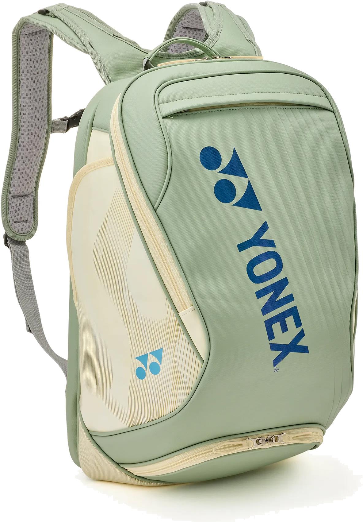 The Yonex 02612EX Expert Badminton Backpack in Smoke Green features padded shoulder straps, a top handle, multiple zippered compartments, and blue Yonex logos—a stylish and practical choice for carrying your badminton gear.