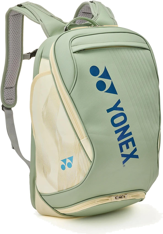 The Yonex 02612EX Expert Badminton Backpack in Smoke Green features padded shoulder straps, a top handle, multiple zippered compartments, and blue Yonex logos—a stylish and practical choice for carrying your badminton gear.