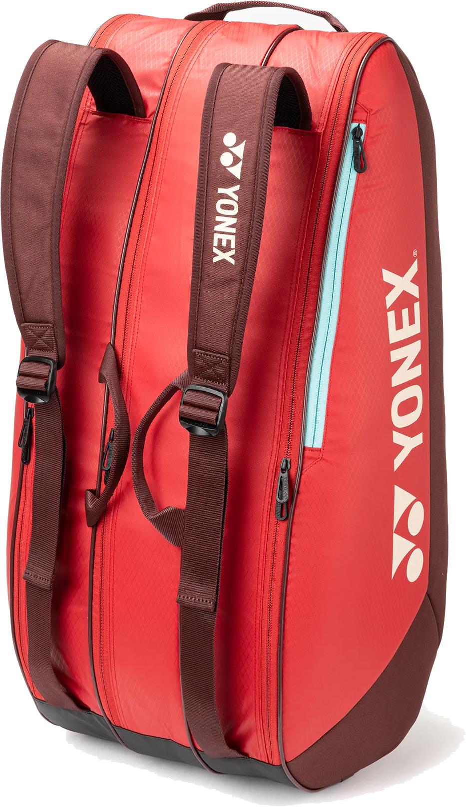 The Yonex 42529EX Team 9 Racket Badminton Bag in ruby red features brown straps, a side zipper pocket lined in light blue, and the Yonex logo in white—ideal for stylishly carrying your gear.